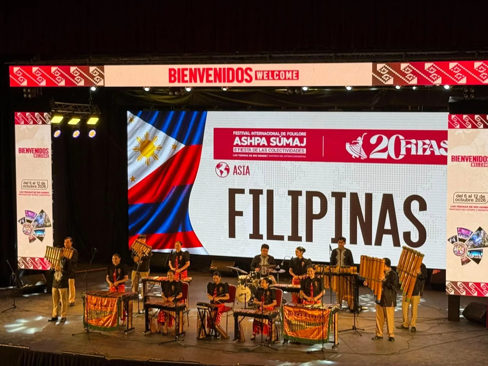 Banda Kawayan Pilipinas performing with bamboo instruments beneath a FILIPINAS display at FIFAS 2026 in Argentina