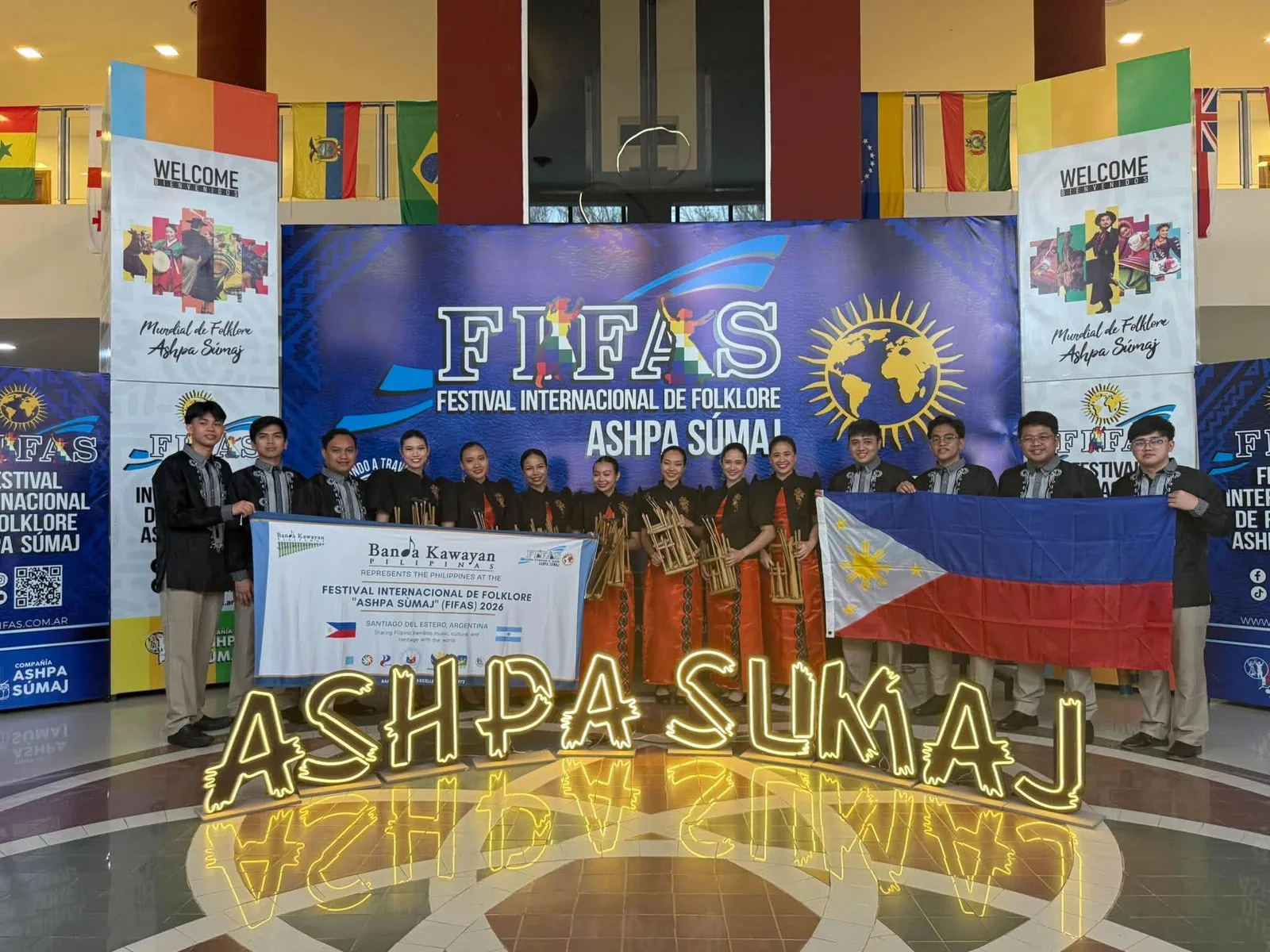 Banda Kawayan Pilipinas members holding the Philippine flag at the Ashpa Súmaj folklore festival in Argentina