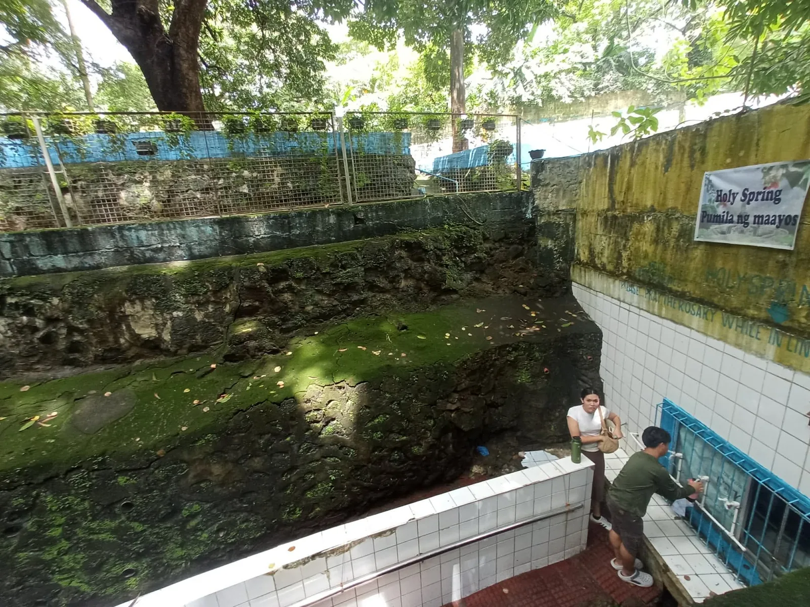 Visitors near the Holy Water Spring area and its tiled walkway