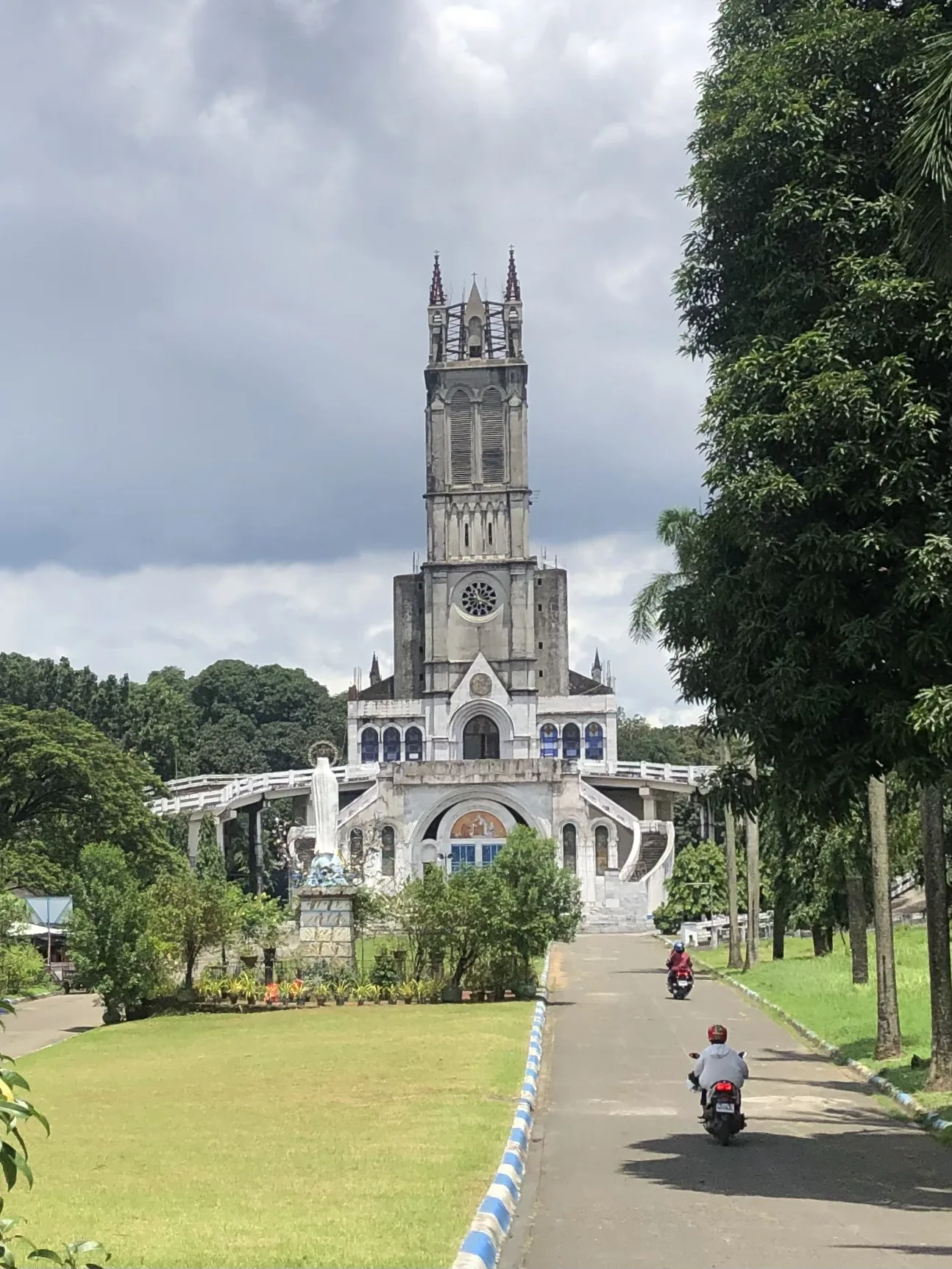 The church at Our Lady of Lourdes Grotto Shrine along a tree-lined approach