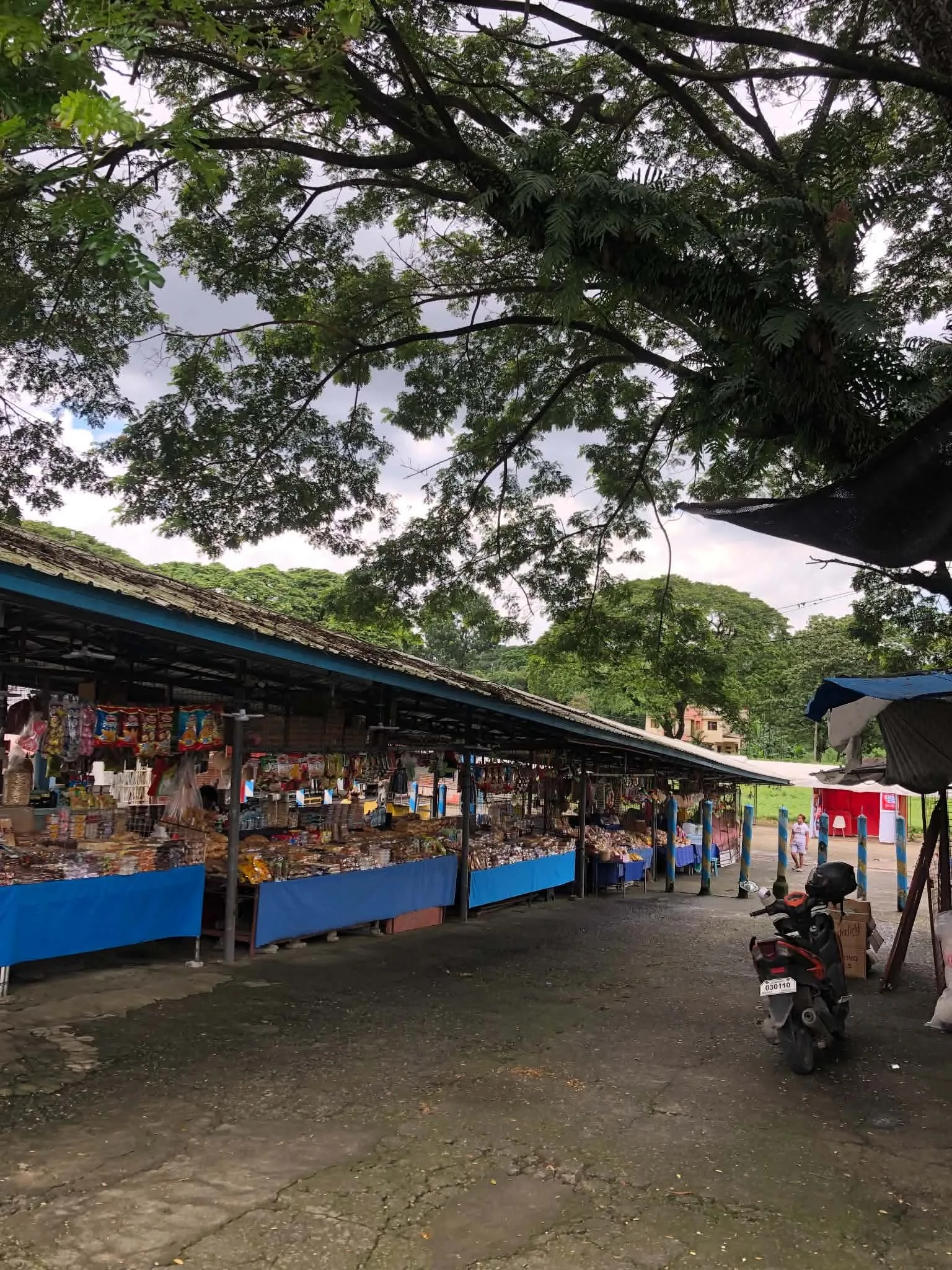 Small market stalls with souvenirs under trees near the shrine