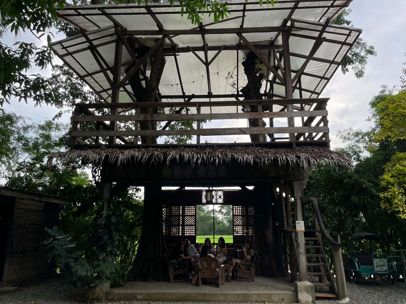 Elevated rustic gathering area among trees at Pulong Kabyawan