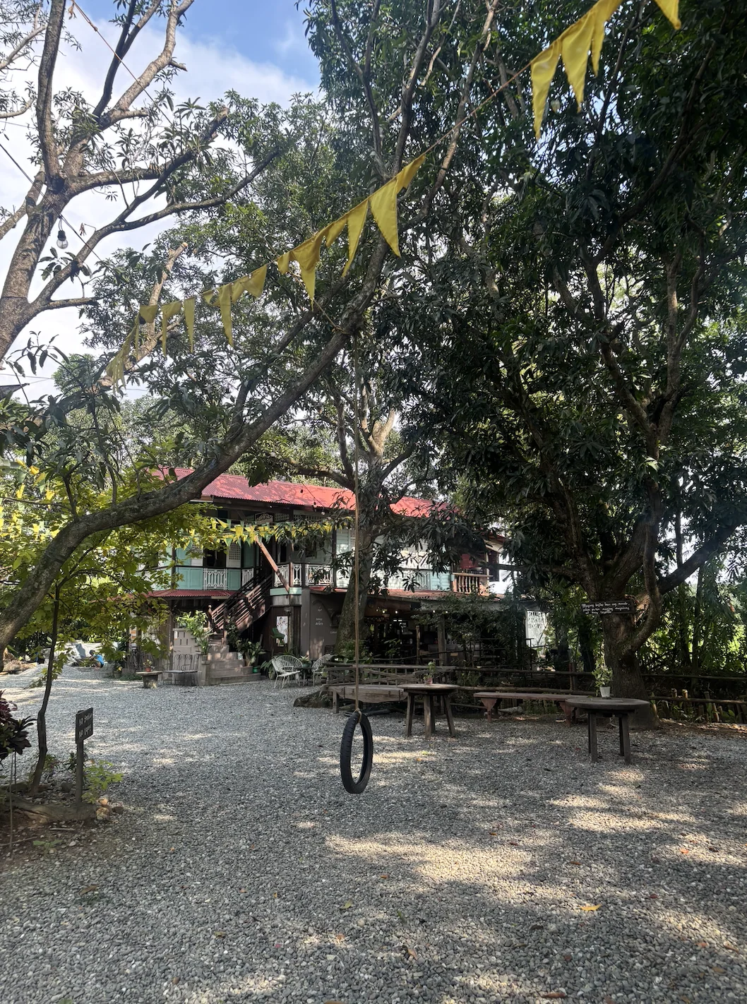 Outdoor seating and a gathering area shaded by trees at Pulong Kabyawan