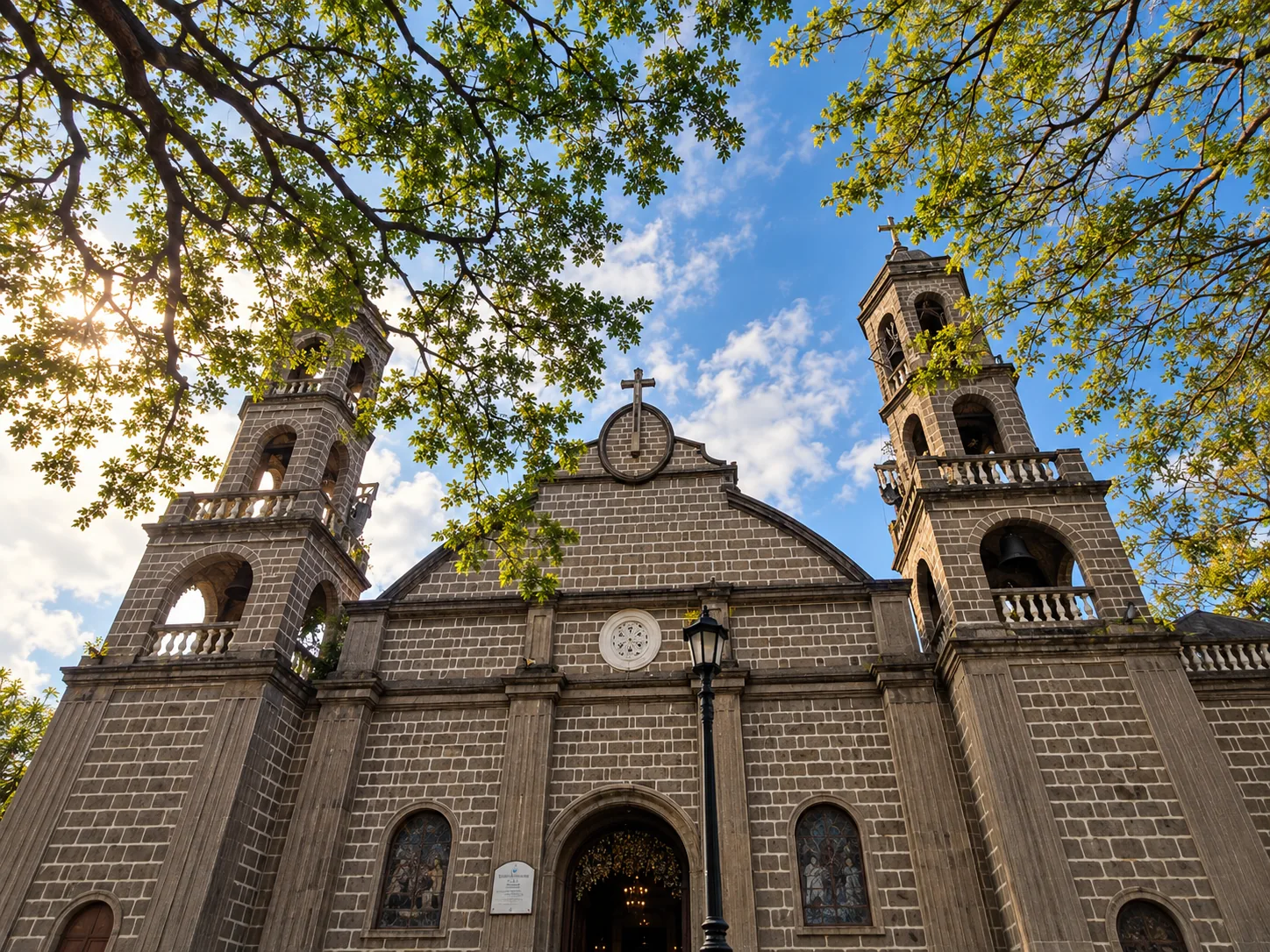 Stone facade and twin bell towers of St. John the Baptist Parish Church in Calamba, Laguna