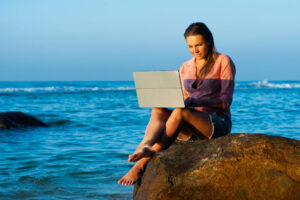 Digital nomad Philippines: woman with laptop at the beach