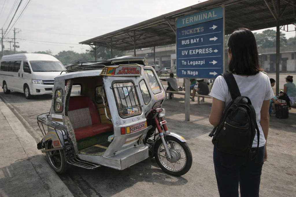 Tricycles, vans, and buses showing how to get around Bicol at a transport hub