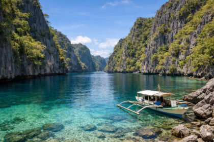 Wide view of Twin Lagoon with limestone cliffs and a boat in Coron