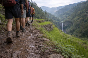 Sagada travel guide trail through rice terraces toward a waterfall in Sagada