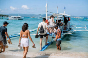 Travelers boarding a boat for a Boracay island hopping tour