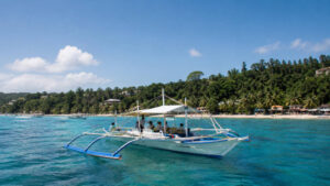 Boracay island hopping boat on calm blue water near the island coastline