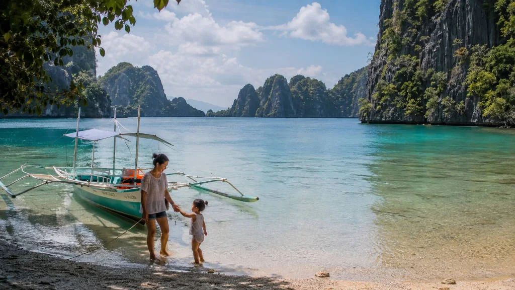 Coron with Kids family-friendly shoreline with calm water and limestone cliffs.
