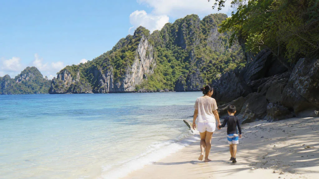 El Nido with kids on a calm family-friendly beach with shallow water and limestone cliffs