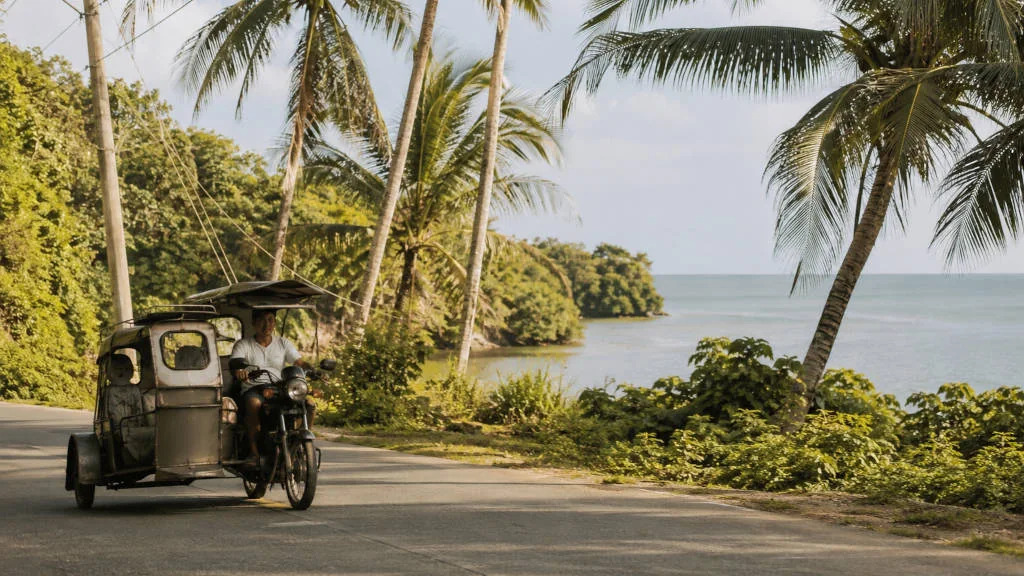 Local transport on a coastal road for how to get around Siquijor