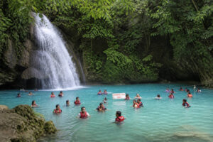 Visitors wearing life vests at the swimming area of Kawasan Falls