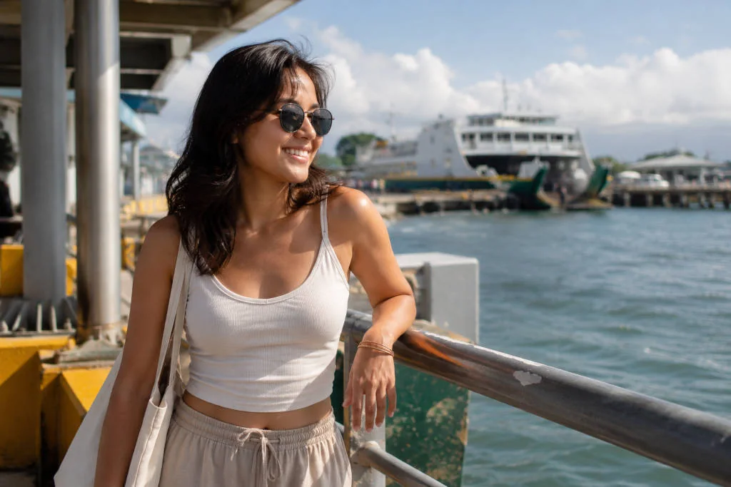 Mika smiling in sunglasses near a ferry terminal before a low-stress Cebu City to Siquijor transfer