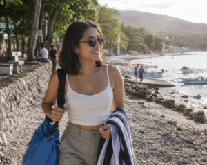 Mika Santos wearing sunglasses while preparing for Oslob whale shark watching with a dry bag and towel