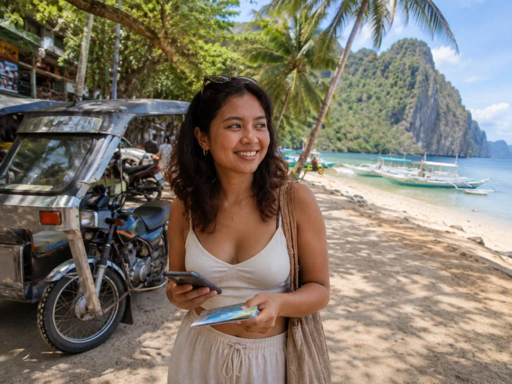 Mika smiling near a beach path while planning things to do in El Nido