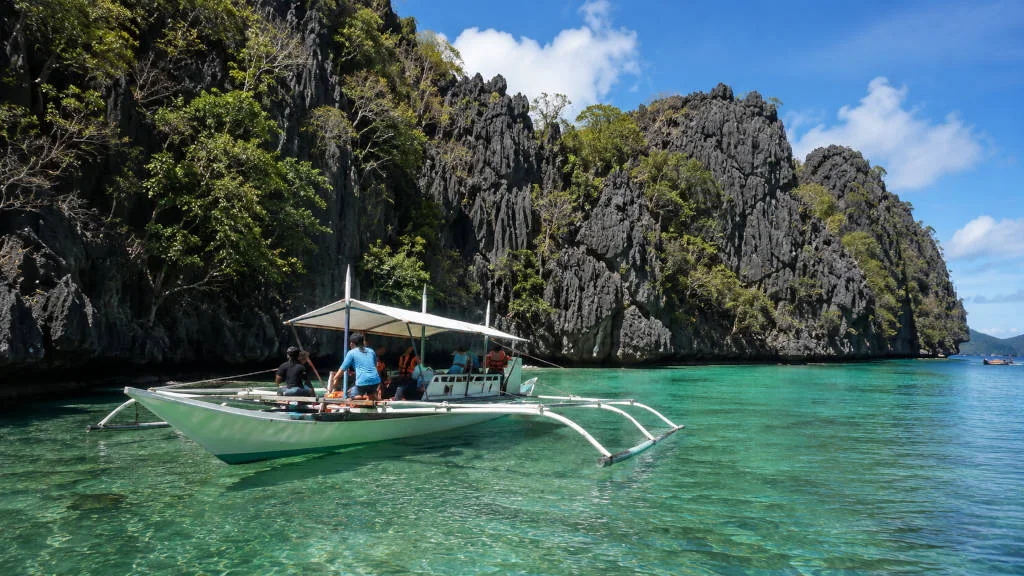Boat near Twin Lagoon in Coron for a twin lagoon entrance fee guide