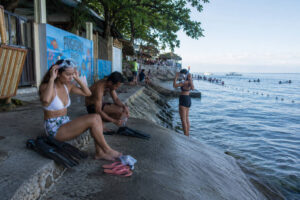 Travelers preparing snorkel gear near Panagsama Beach for the Moalboal Sardine Run